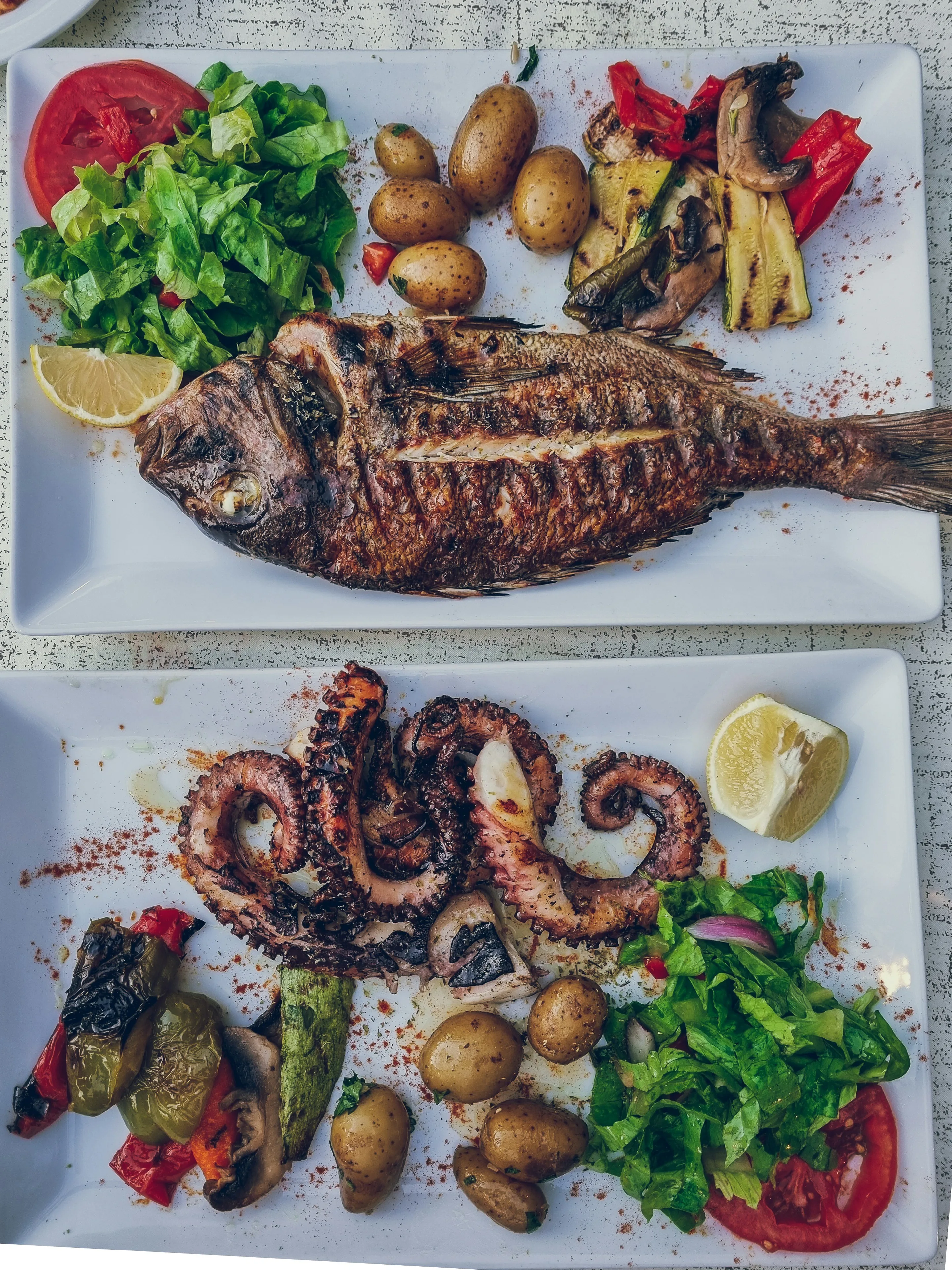 Grilled whole fish and grilled octopus with potatoes, peppers and salad